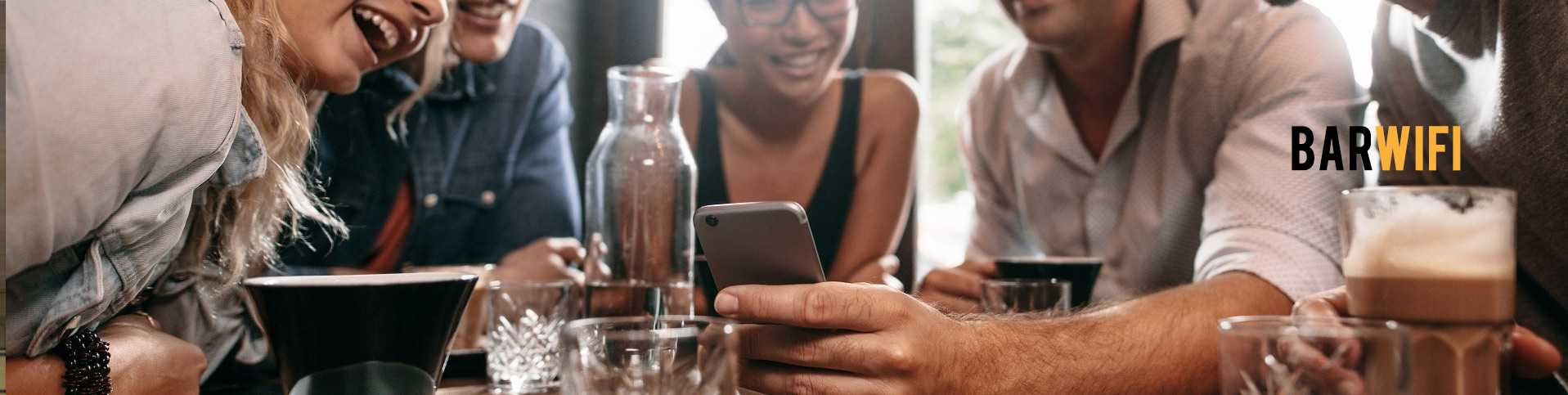 Friends at a bar table looking at a phone, with the words Bar WiFi